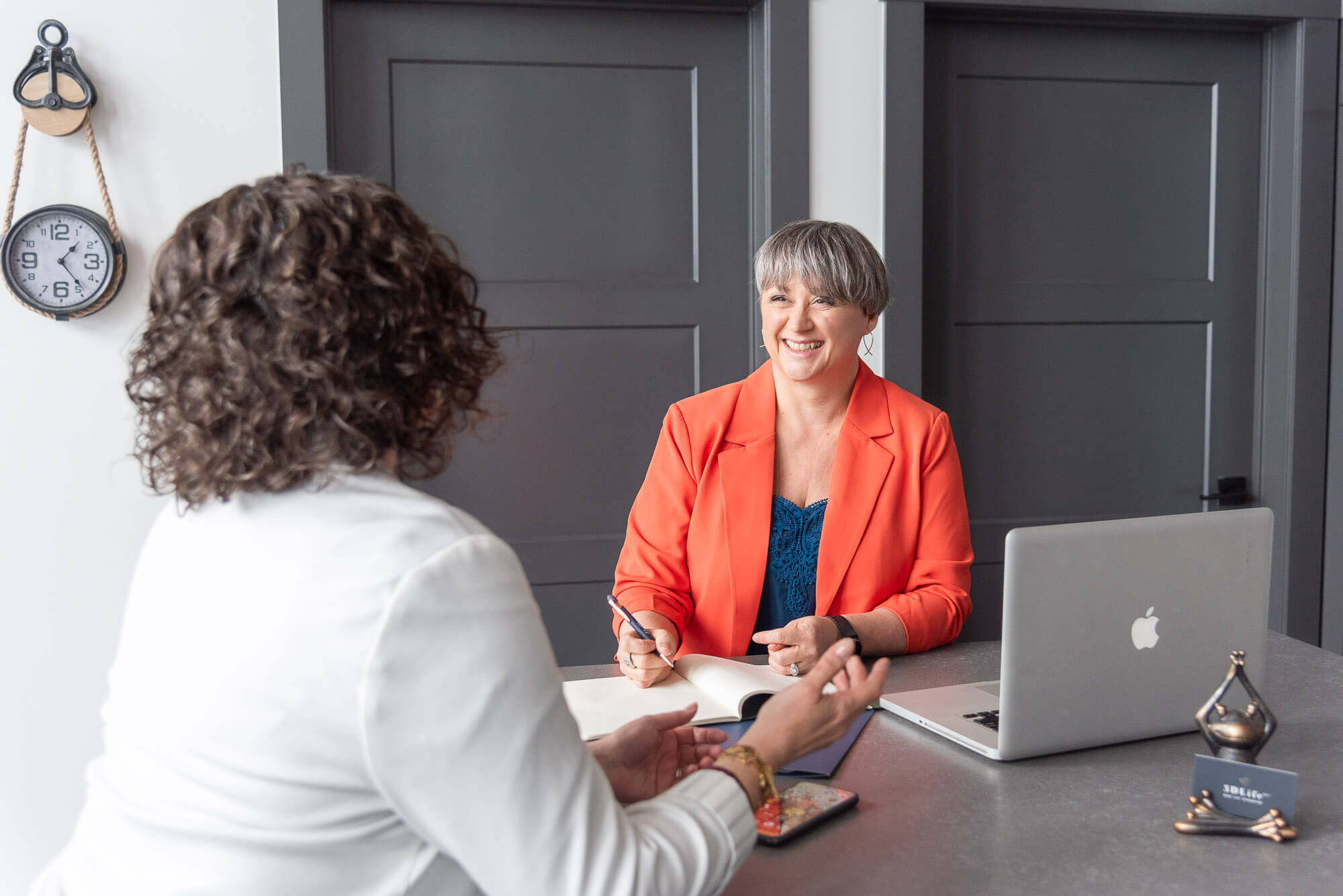 brand photo customer experience shot with 2 service based woman talking at a tablewomen