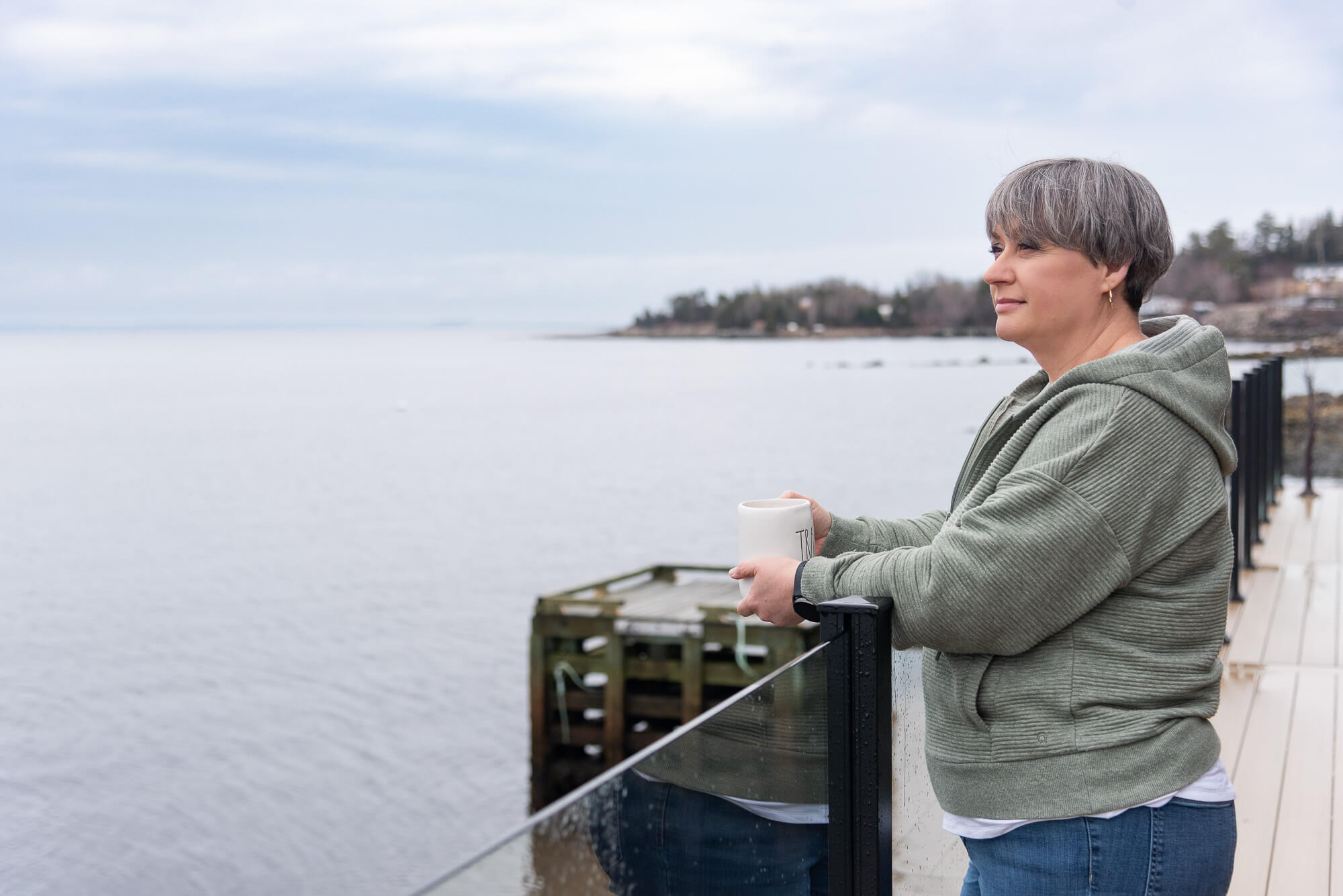 brand photo of a service based entrepreneur having coffee on the deck overlooking the ocean