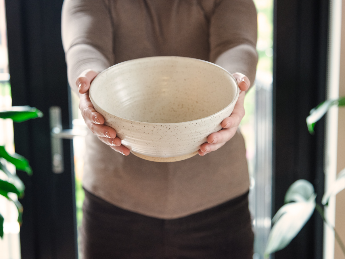 Potter hold out custom glazed bowl during Halifax Brand Photography shoot with Dandelion Digital