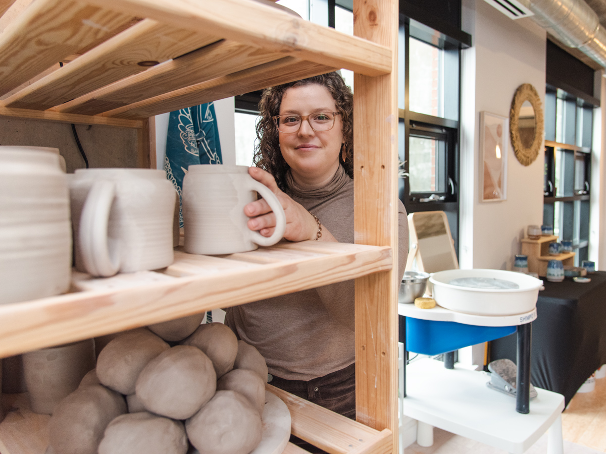 Potter with shelf of ready to use clay balls and ready to kiln mugs in studio during Halifax Brand Photography shoot with Dandelion Digital
