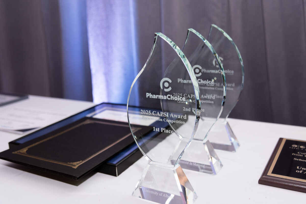 3 glass CAPSI awards and 2 black certificate folios on table