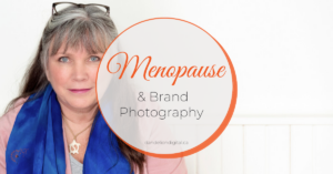 Blog title "Menopause & Brand Photography shows a white women with greying hair and beautiful blue eyes wearing a pink sweater with a bright blue silk scarf