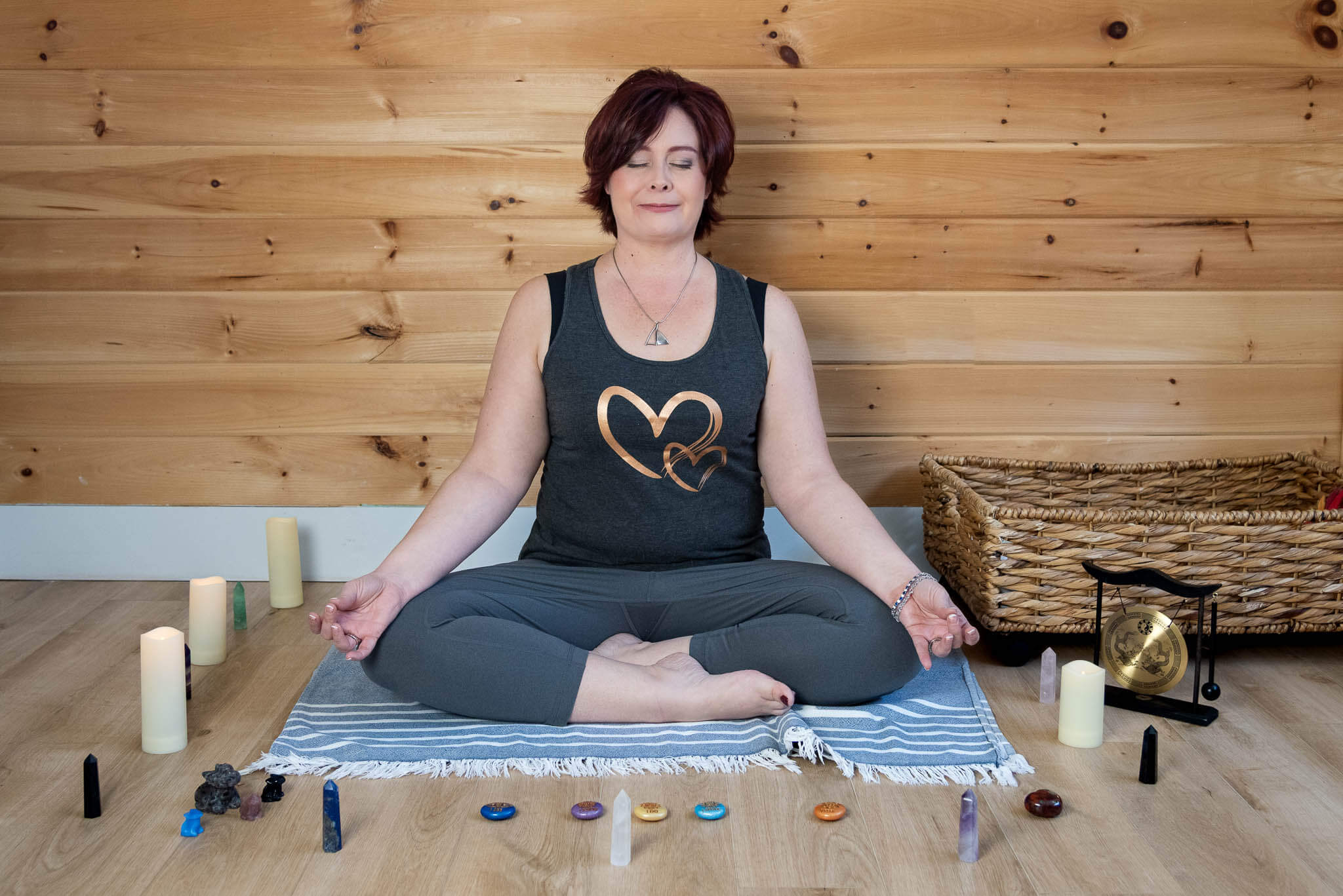 Resilience coach and author sits cross-legged in meditation, surrounded by candles and crystals, during a Halifax mini brand photography session.