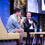 2 men in chair on stage, including actor Ben McKenzie at hal-Con