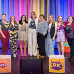 the Halifax Chamber of Commerce planning committee for the Wonder Women conference includes 8 women and a man on a stage with colourful drapes