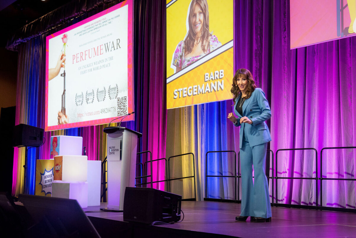 Keynote speaker Barb Stegemann on colourfully draped stage at Halifax Chamber of Commerce Wonder Women Conference