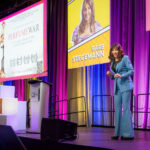 Keynote speaker Barb Stegemann on colourfully draped stage at Halifax Chamber of Commerce Wonder Women Conference