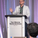 man at podium in Westin Nova Scotian Hotel ballroom giving keynote