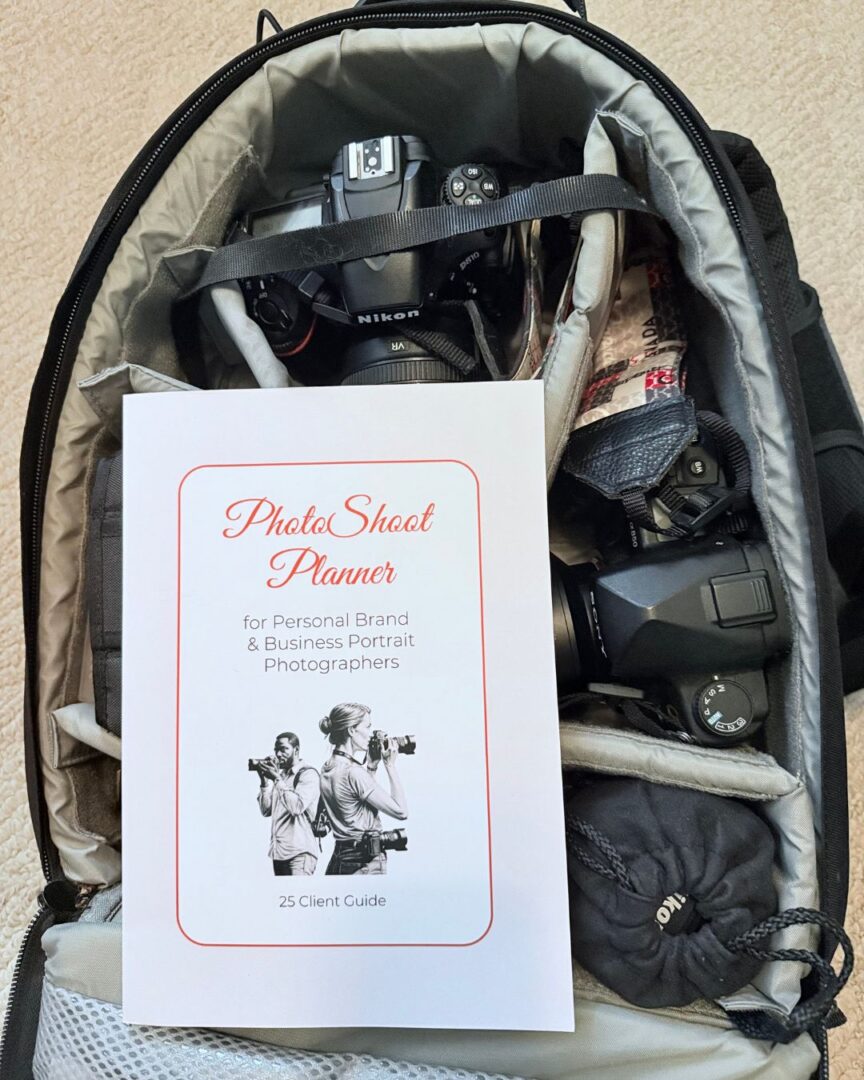 an open camera bag with a softcover PhotoShoot Planner on top of kit