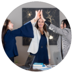 photo of 3 women giving high fives over a boardroom table