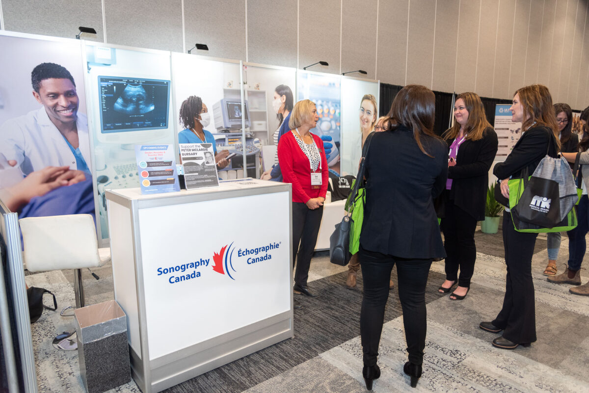 4 women gathering at Sonography Canada booth in trade show at Halifax Convention Centre