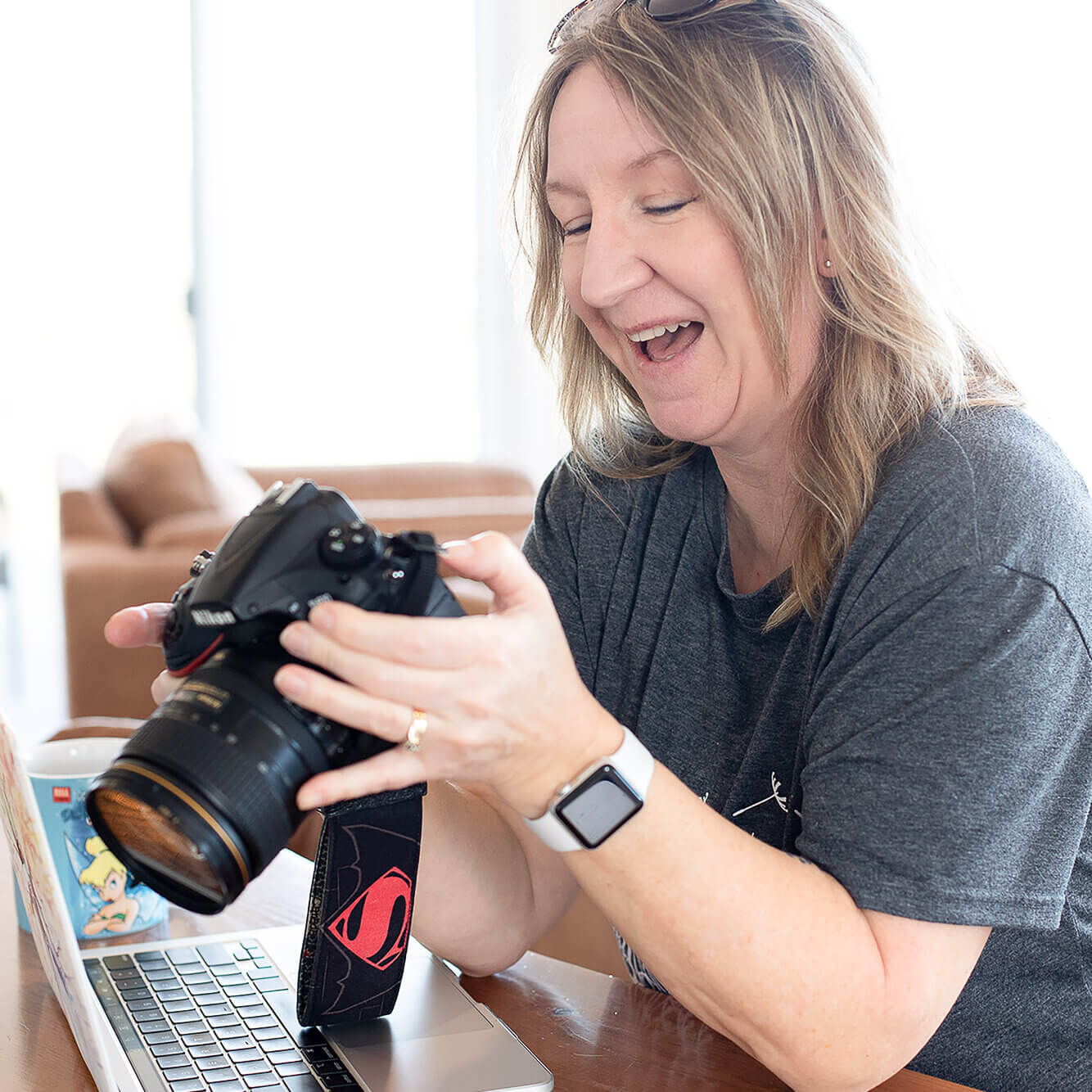 Allison Smith, blond Halifax Brand Photographer laughing while looking at the back of her camera after a personal brand photoshoot in Annapolis Valley, Nova Scotia