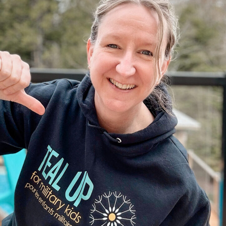 blond woman point a shirt that says TealUp with a dandelion. This is in support of the military kids
